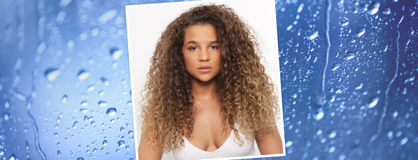 Image of a model with curly hair with a beaded water background.