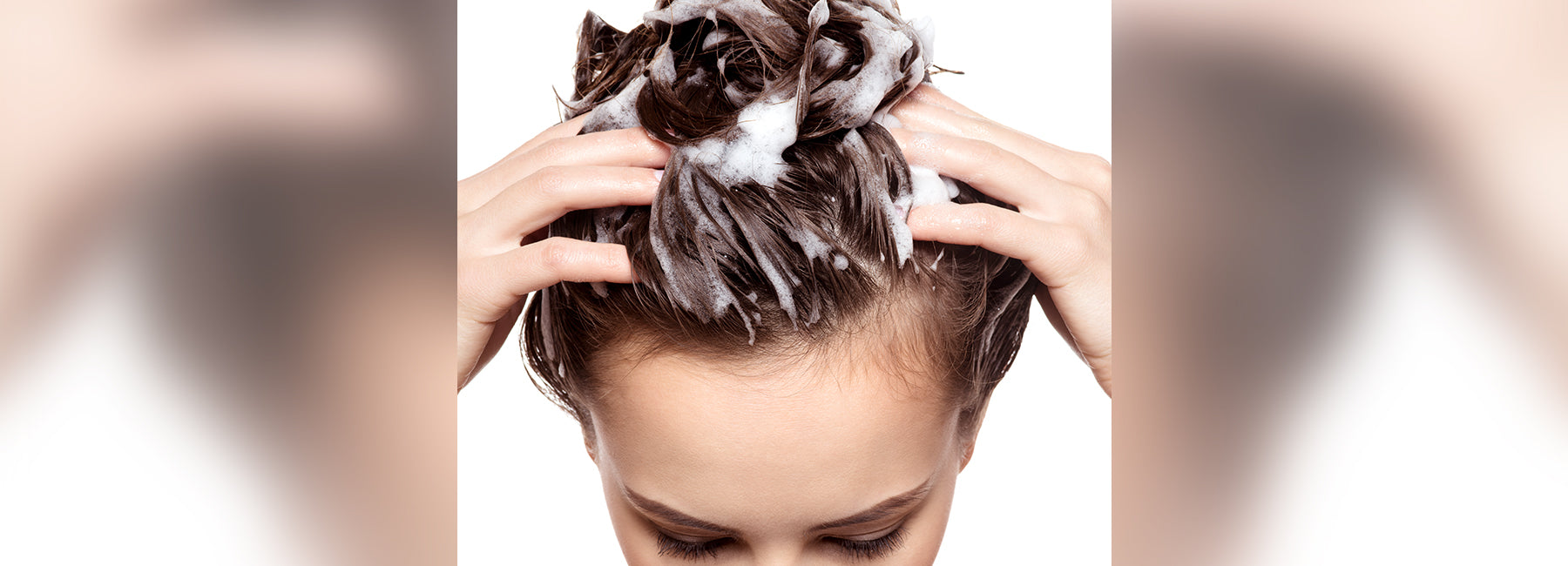 Woman lathering shampoo in her hair. 