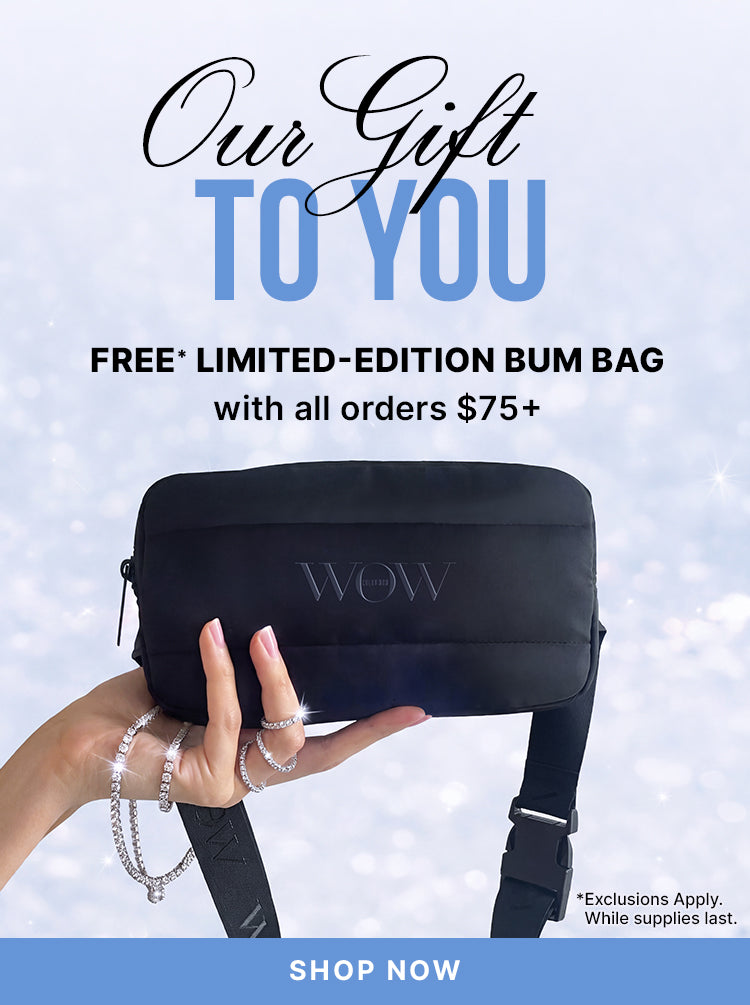 A hand holds a black limited-edition bum bag against a sparkling background. Text: Our Gift to You—free limited-edition bum bag with orders of $75 or more. Exclusions apply; while supplies last. Shop now.