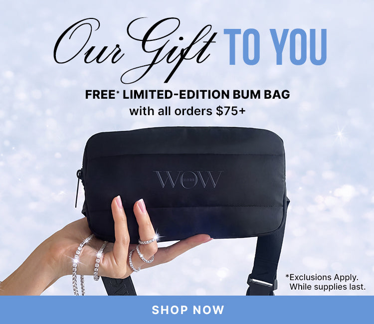 A hand holds a black limited-edition bum bag against a sparkling background. Text: Our Gift to You—free limited-edition bum bag with orders of $75 or more. Exclusions apply; while supplies last. Shop now.