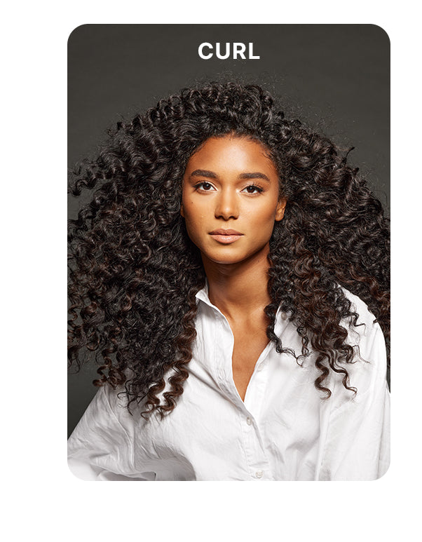 Model with long, voluminous, defined curls wearing a white button-up shirt against a dark gray background. Bold white text above reads: “CURL.”