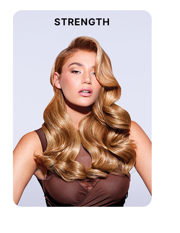 Model with voluminous, glossy, golden blonde waves styled in a deep side part, wearing a sleeveless brown top against a pale lavender background. Bold black text above reads: “STRENGTH.”